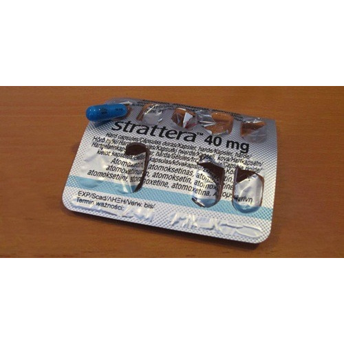 Strattera 40mg (Atomoxetine HCl) blister pack placed on wooden surface showing printed dosage
